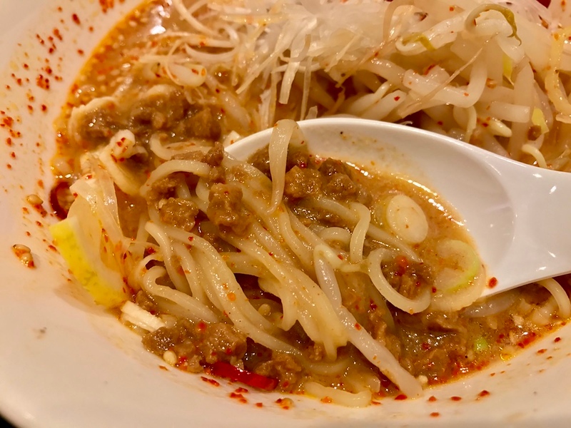 Chunks of tasty, spicy soy meat tangled up in the noodles - check out that orange-red soup!