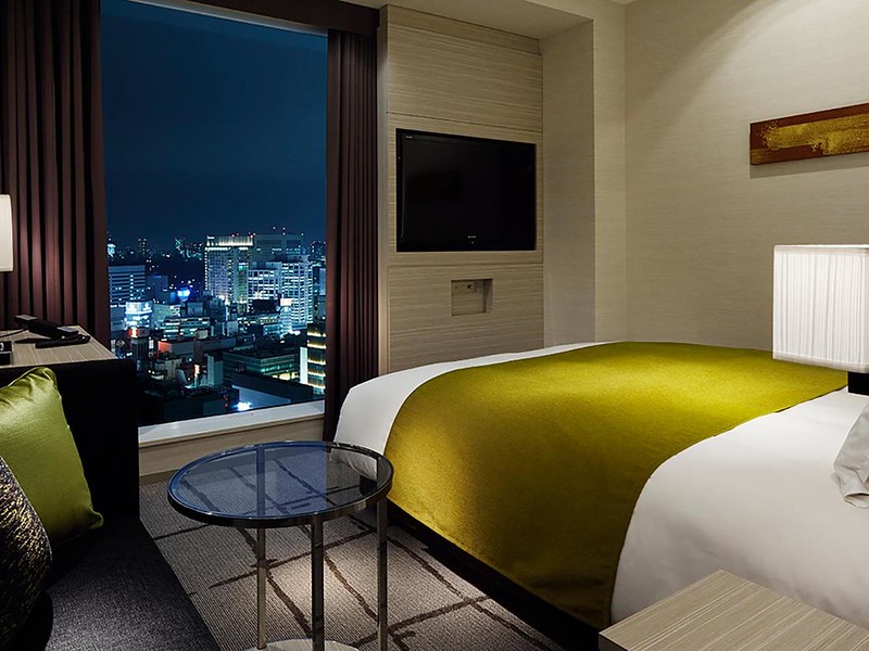 Double bed with view of Tokyo nighttime skyscape in the Mitsui Garden Ginza Premier hotel, Japan