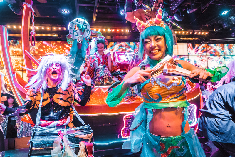 Wild performers in lurid costumes pull faces for the camera at the Robot Restaurant in Tokyo, Japan