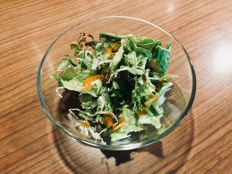 Free small salad with an onion-heavy dressing served at lunch. Free small salad with an onion-heavy dressing served at lunch.
