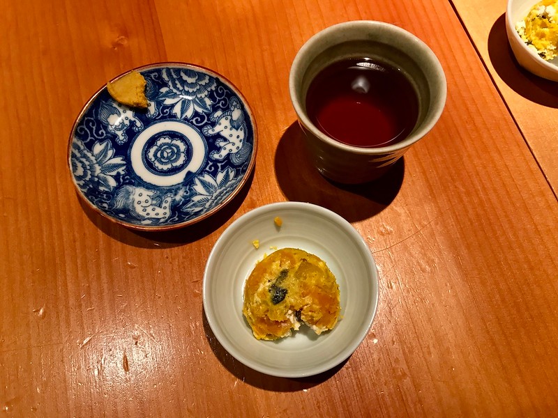 Tea, appetizer, and a small dish for tonkatsu sauce.