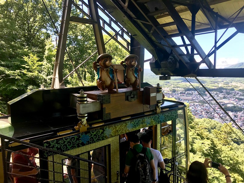 Tanuki, or raccoon dogs, on top of the cable car.