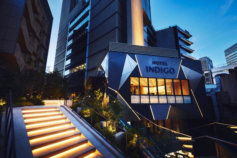 The illuminated staircase leading to the geometric entrance to the Hotel Indigo Tokyo Shibuya at night