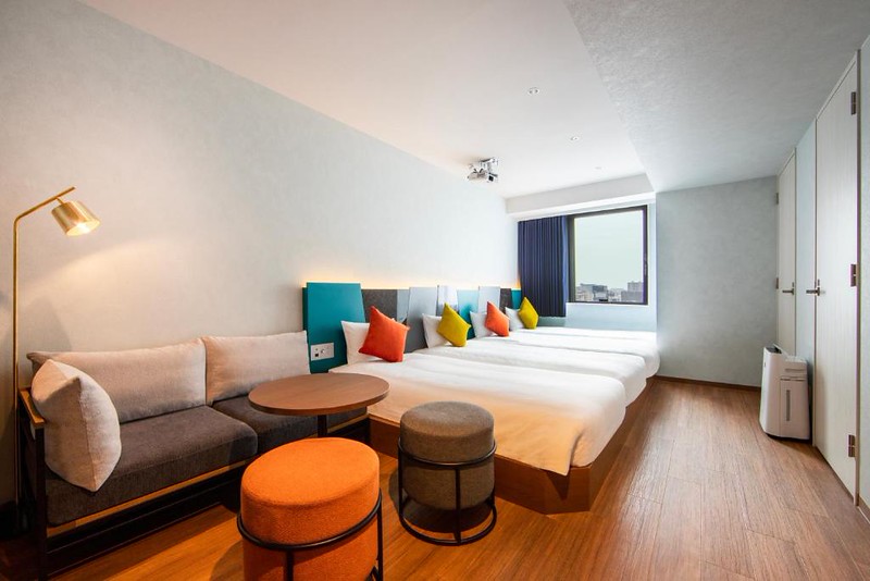 Four beds side by side with a sofa in a karaksa hotel colors Tokyo Yaesu comfort quad room Four beds side by side with a sofa in a karaksa hotel colors Tokyo Yaesu comfort quad room