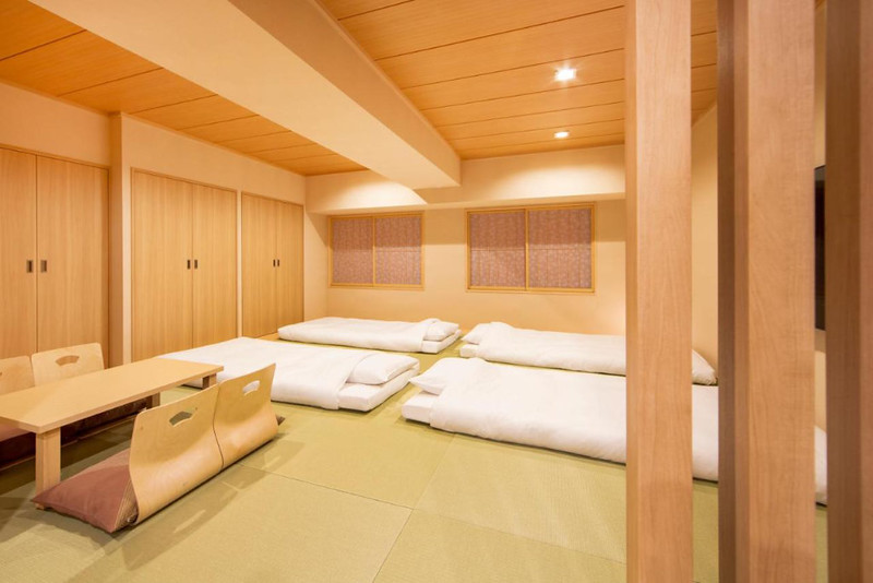 Japanese-style family room in the Karaska Hotel Tokyo Station with four mattresses and floor-level seating around a table