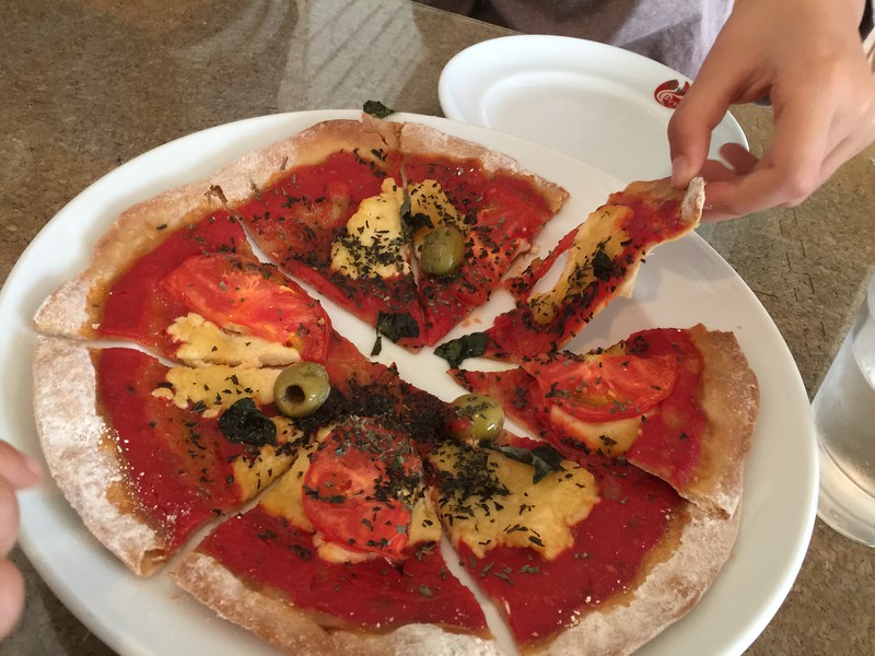 Little fingers and a vegan cheese olive pizza