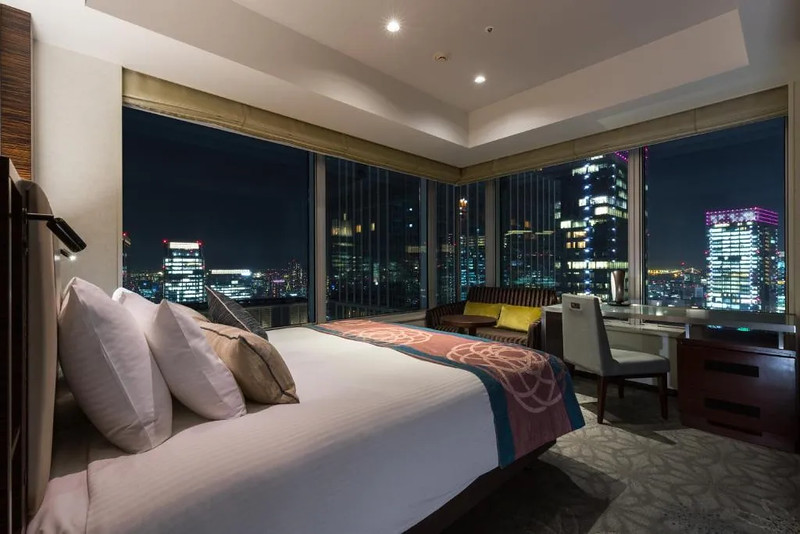 Hotel Metropolitan Tokyo Marunouchi corner room with king-sized bed and desk overlooking the Tokyo nightscape