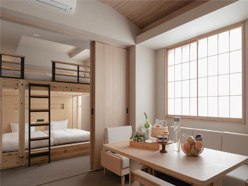 Wooden family room with twin beds and overhead bunks, and living area in the Mimaru Suites Tokyo Nihombashi hotel