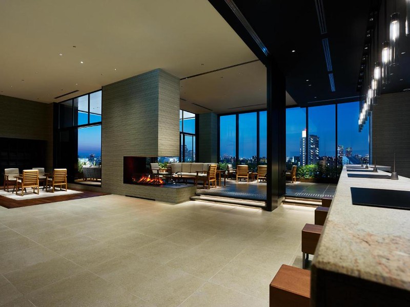 The spacious and elegant lobby in the Mitsui Garden Hotel Gotanda Tokyo with open fire and tall windows giving a view of the city