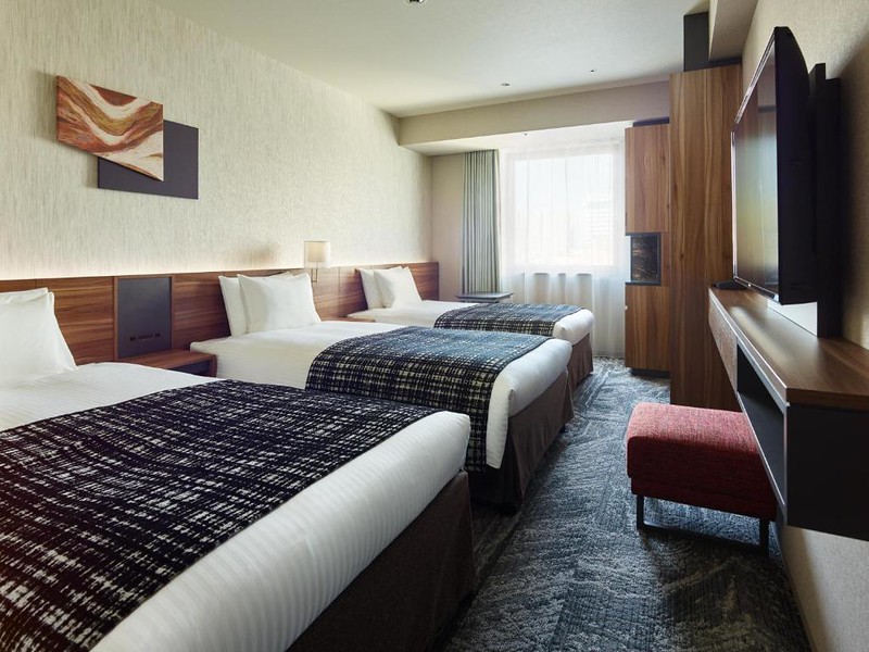 Three large beds and a TV in a Mitsui Garden Hotel Gotanda Tokyo triple room