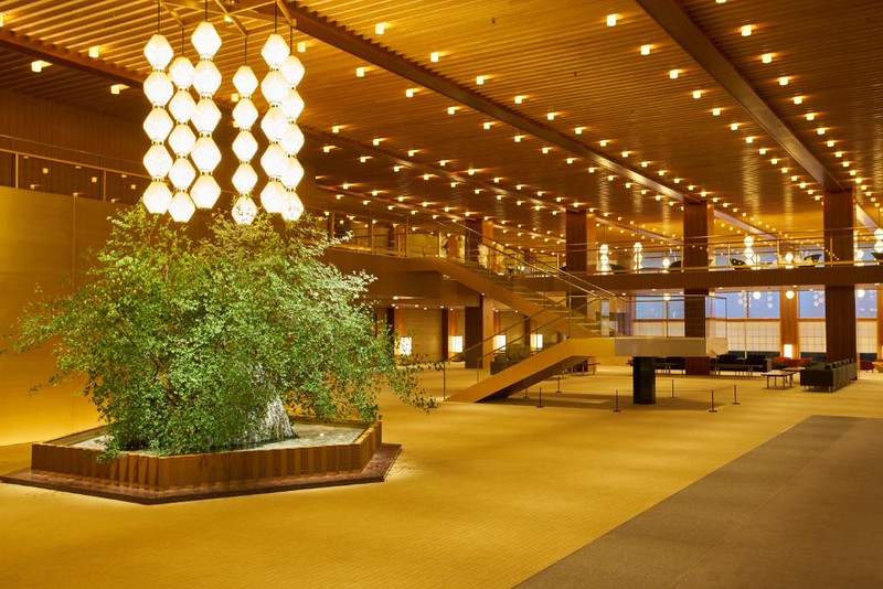 Spacious lobby area of The Okura Tokyo hotel with indoor tree and lots of stylish lighting