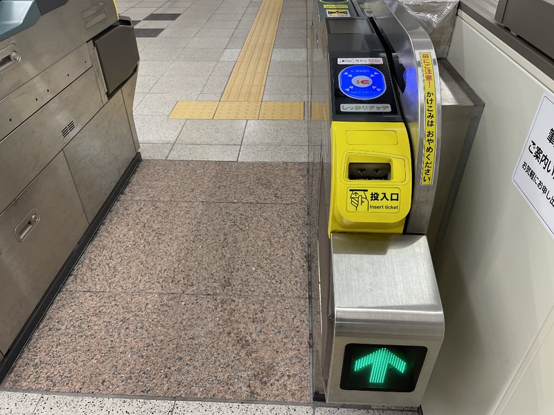Metro station ticket gate with yellow machine for inserting regular tickets