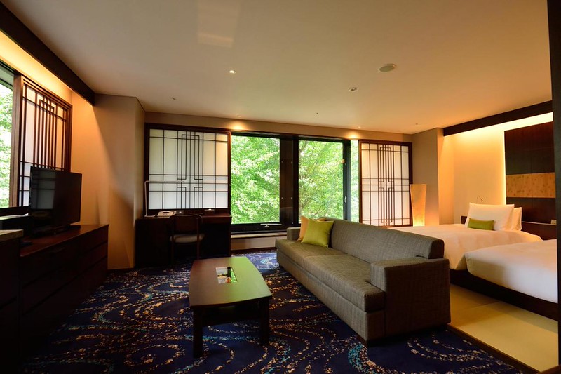 Traditional Japanese elements with sofa and large twin beds in the Hotel Ryumeikan Ochanomizu Honten, Tokyo, Japan Traditional Japanese elements with sofa and large twin beds in the Hotel Ryumeikan Ochanomizu Honten, Tokyo, Japan