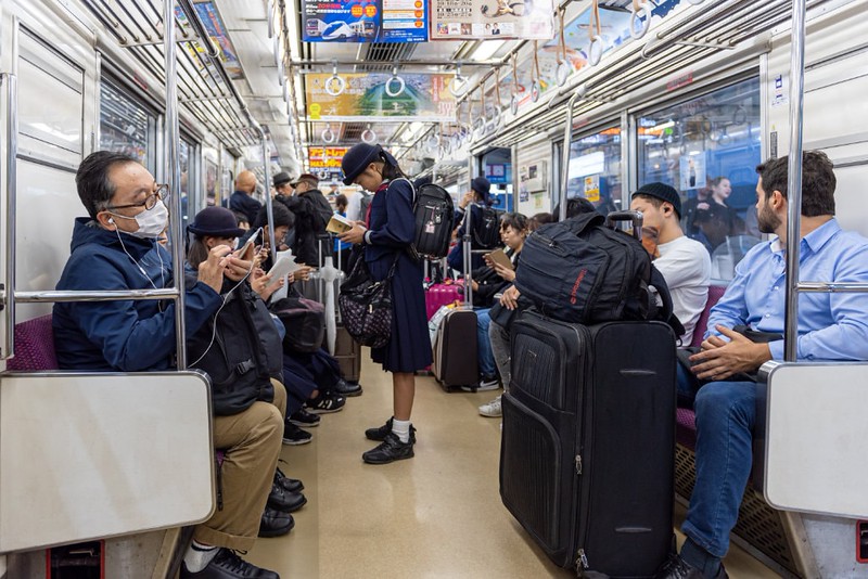 A Keisei Main Line Rapid Limited Express train, packed with passengers, travelling from Narita Airport to Tokyo city centre