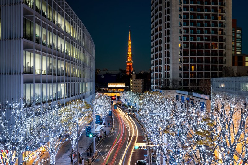 Tokyo Tower lit up in orange with Christmas illumination at Roppongi, Tokyo, Japan and time lapse light trails from the traffic