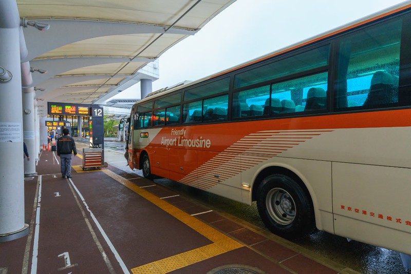 An orange and white airport limousine bus waits at Narita Airport in Tokyo