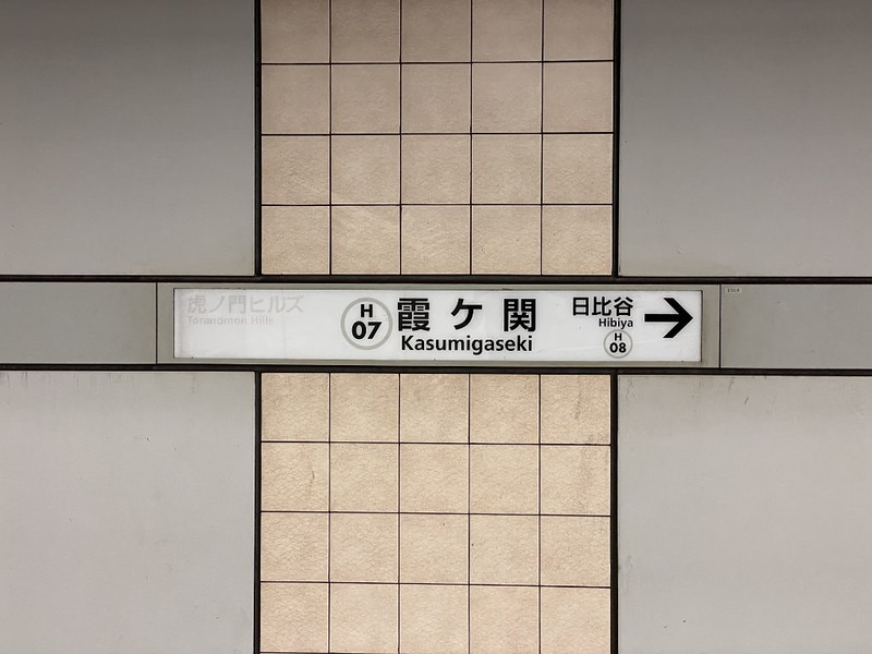 Sign for Kasumigaseki station on the platform of a Tokyo metro station