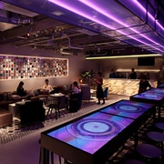 Pink neon and atmospheric lighting as people relax in the lounge of The Millennials capsule hotel in Tokyo