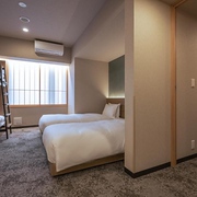 Back-to-back twin rooms with additional bunk beds in a minimal apartment in the Mimaru Tokyo Ikebukuro hotel