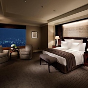 Ritz-Carlton Tokyo hotel guest room with double bed and nighttime views of the city outside
