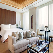 The Peninsula Tokyo guest room with double bed, sofa and living area, and nighttime views of the Tokyo skyline