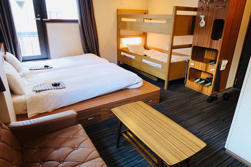 Modular wooden and leather family room with joined twin beds and child bunks in the Tokyo Ueno Touganeya hotel, Japan