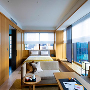 Double bed and living area of a guest room in The Okura Tokyo hotel with twilight views of the city outside