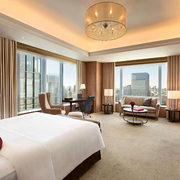 Large suite-style corner room in the Shangri La Tokyo hotel with skyscraper views outside