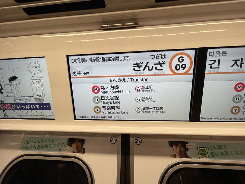 Information screen in a Tokyo metro car with details of transportation transfer options at the approaching train station