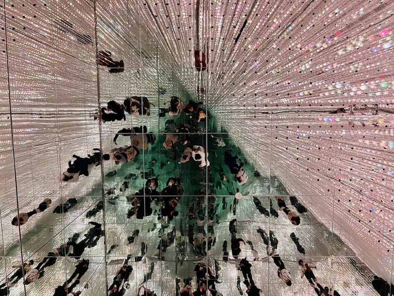 Reflections of visitors in the mirrors lining an infinity room in Tokyo’s teamLab Borderless in Azabudai Hills