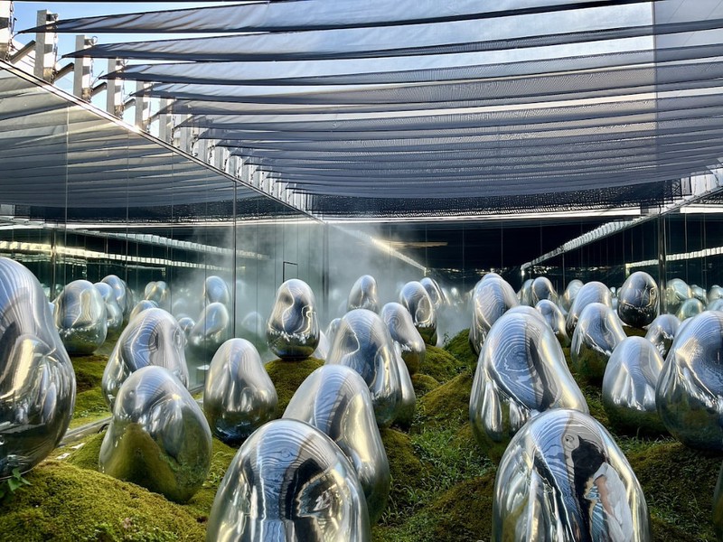 Strange, metallic, silver rocks sit in a moss garden in the teamLab Planets museum, Tokyo, Japan