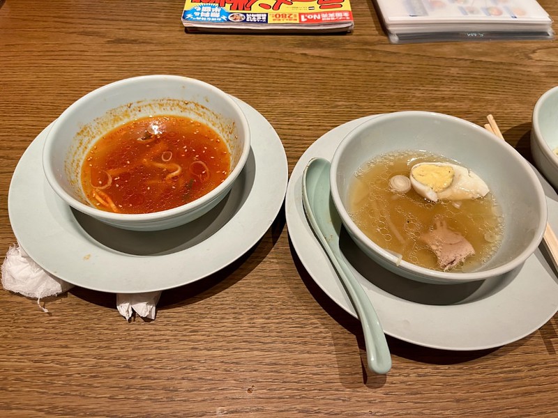 Two half-finished bowls of different-flavoured ramen sat on the table of a Tokyo restaurant