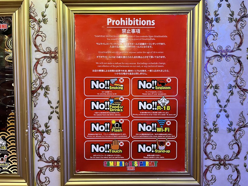 A gold-framed poster in Samurai Restaurant Time with a list of prohibited activities, including no sunglasses