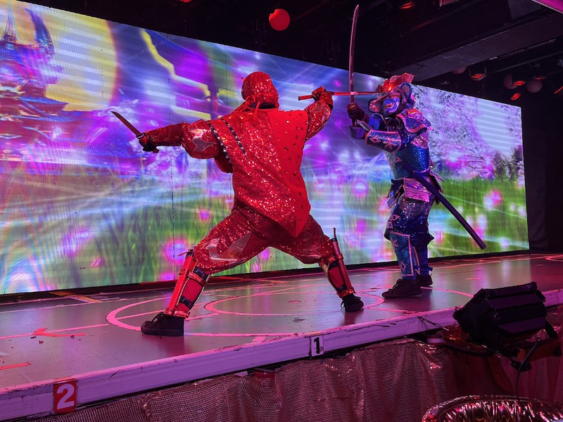 A ninja dressed in red battles it out in a sword fight with another dressed in blue at Samurai Restaurant Time