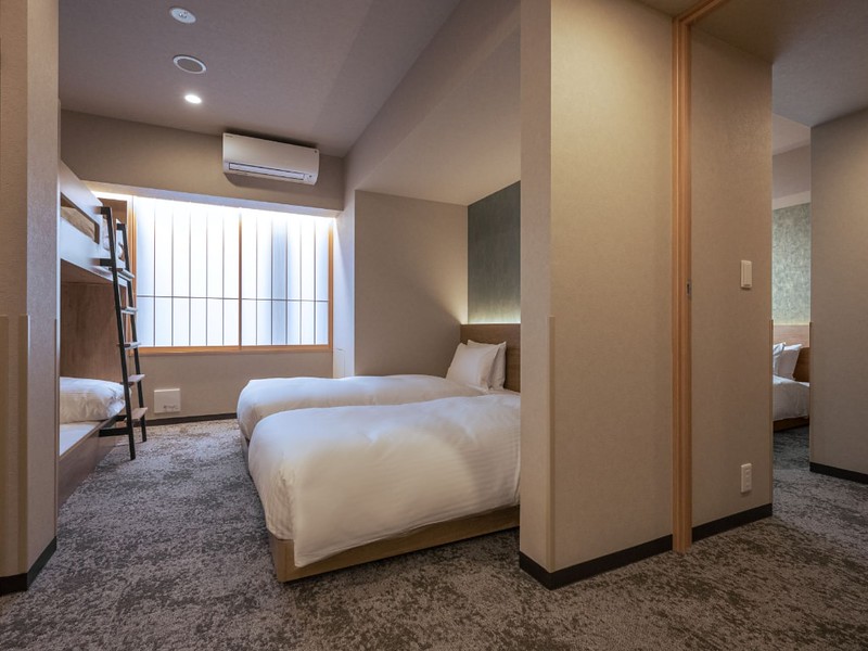 Back-to-back twin rooms with additional bunk beds in a minimal apartment in the Mimaru Tokyo Ikebukuro hotel