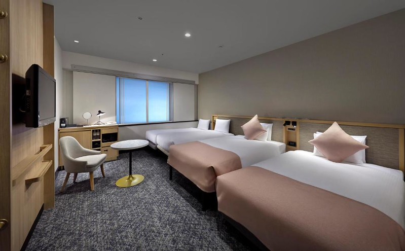 Large twin beds and two smaller singles in a guest room in Hotel Villa Fontaine Shiodome-Tokyo